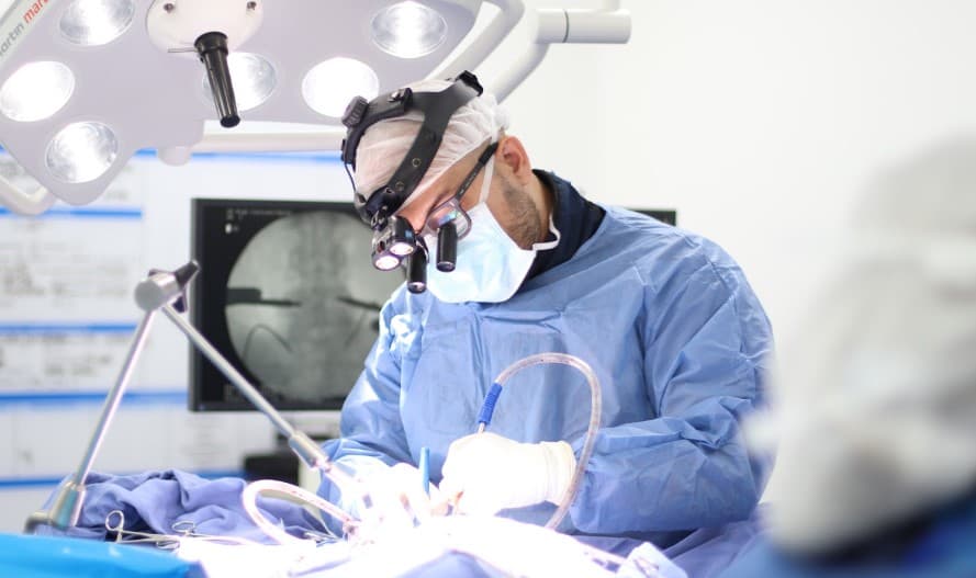Dr. Juan Carlos Pérez realizando una cirugía de columna - Colsubsidio